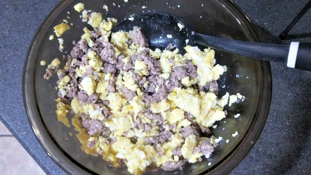 A large bowl filled with scrambled eggs and ground sausage