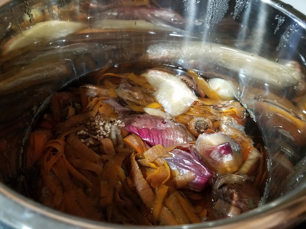 Making your own vegetable broth is frugal and easy! Here's how to do it using a slow cooker and leftover veggie scraps from your freezer!