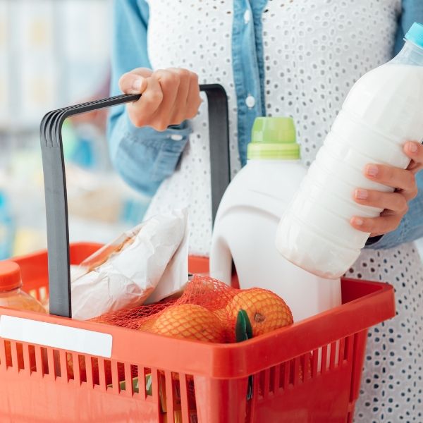 A woman holding a basket of groceries