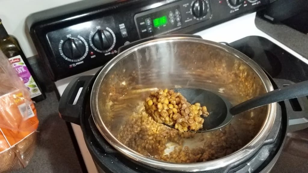 Image of a spoon holding cooked lentils