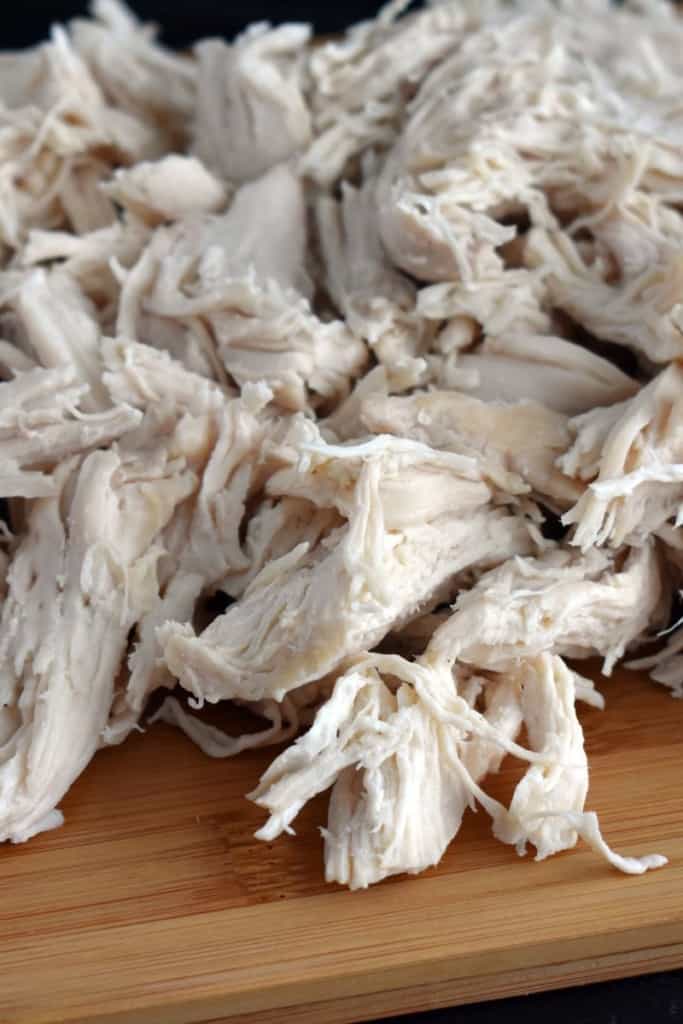 Cooked shredded chicken on a cutting board