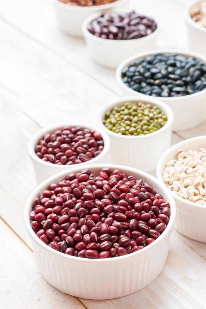 Various dried beans in white bowls