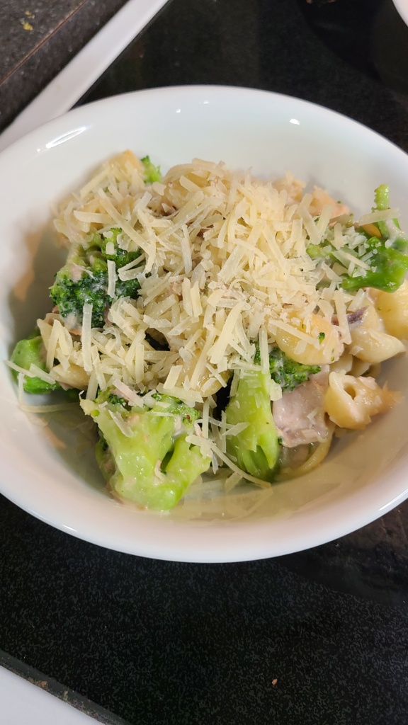 A bowl filled with finished Knorr garlic shells, topped with shredded Parmesan