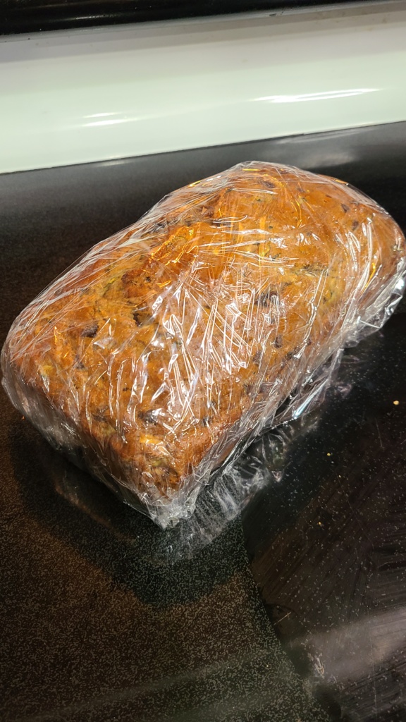 A loaf of zucchini bread wrapped in plastic wrap