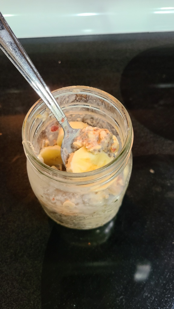 A Mason jar filled with overnight oats and a sliced banana