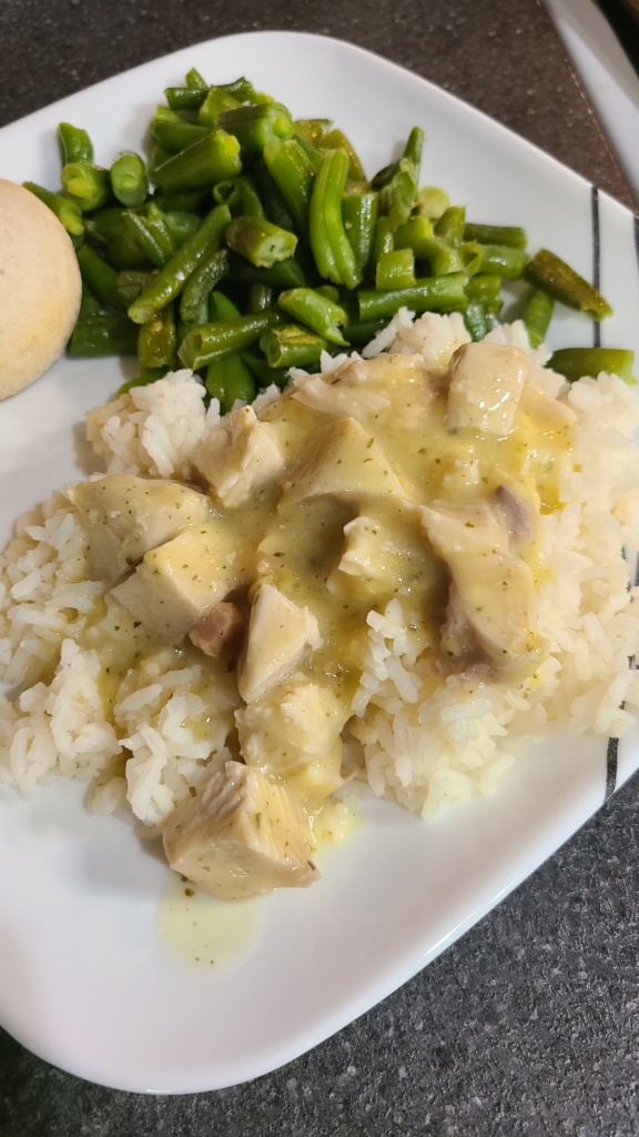 Ranch chicken on top of white rice, next to roasted green beans and biscuits