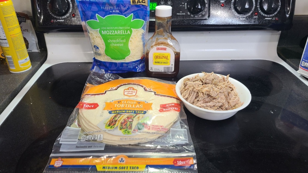 Ingredients for pulled pork quesadillas, on a stovetop