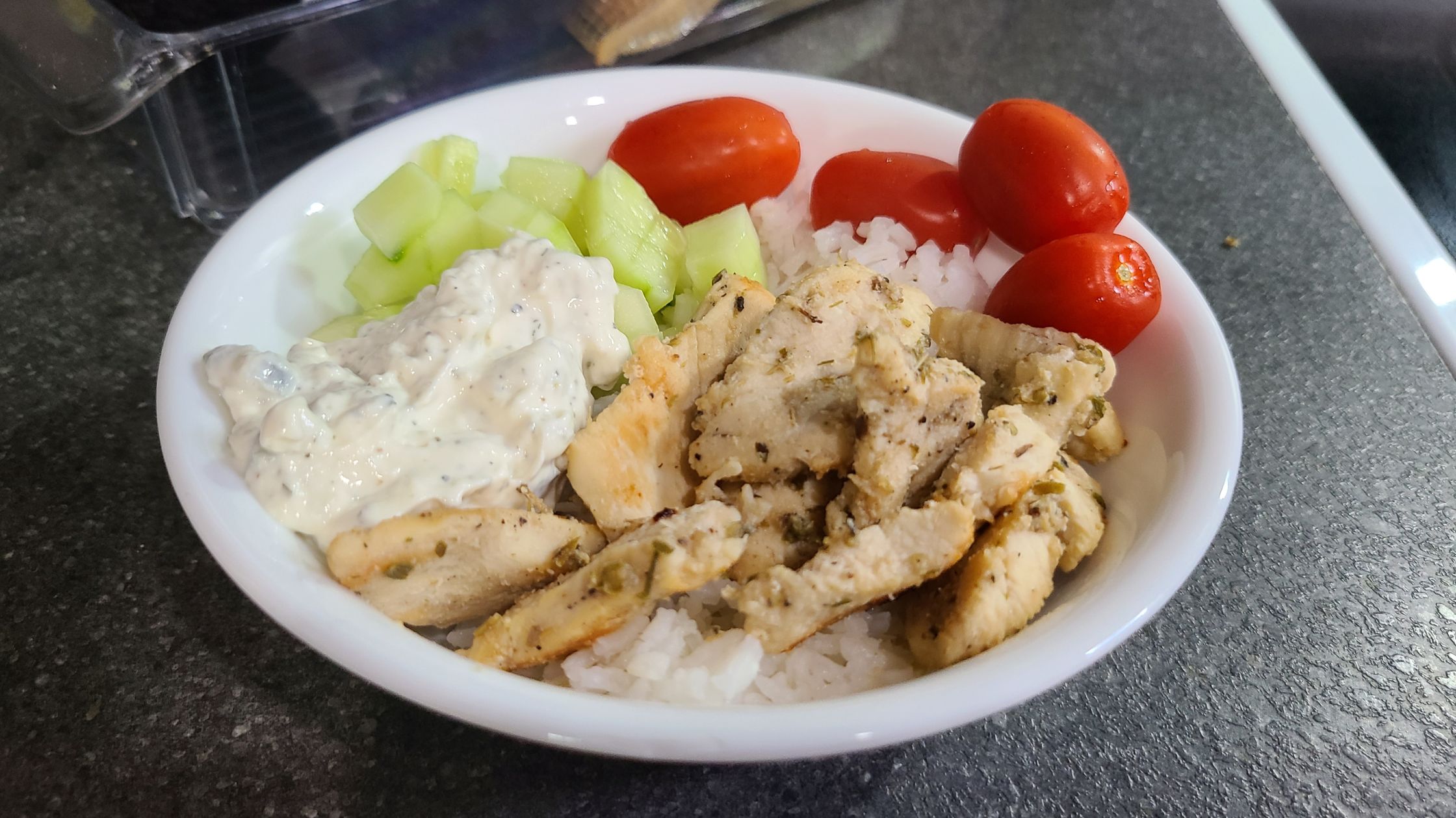 Greek chicken bowl sitting on a countertop