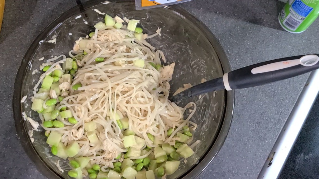 A large bowl filled with all ingredients for sesame noodle salad.