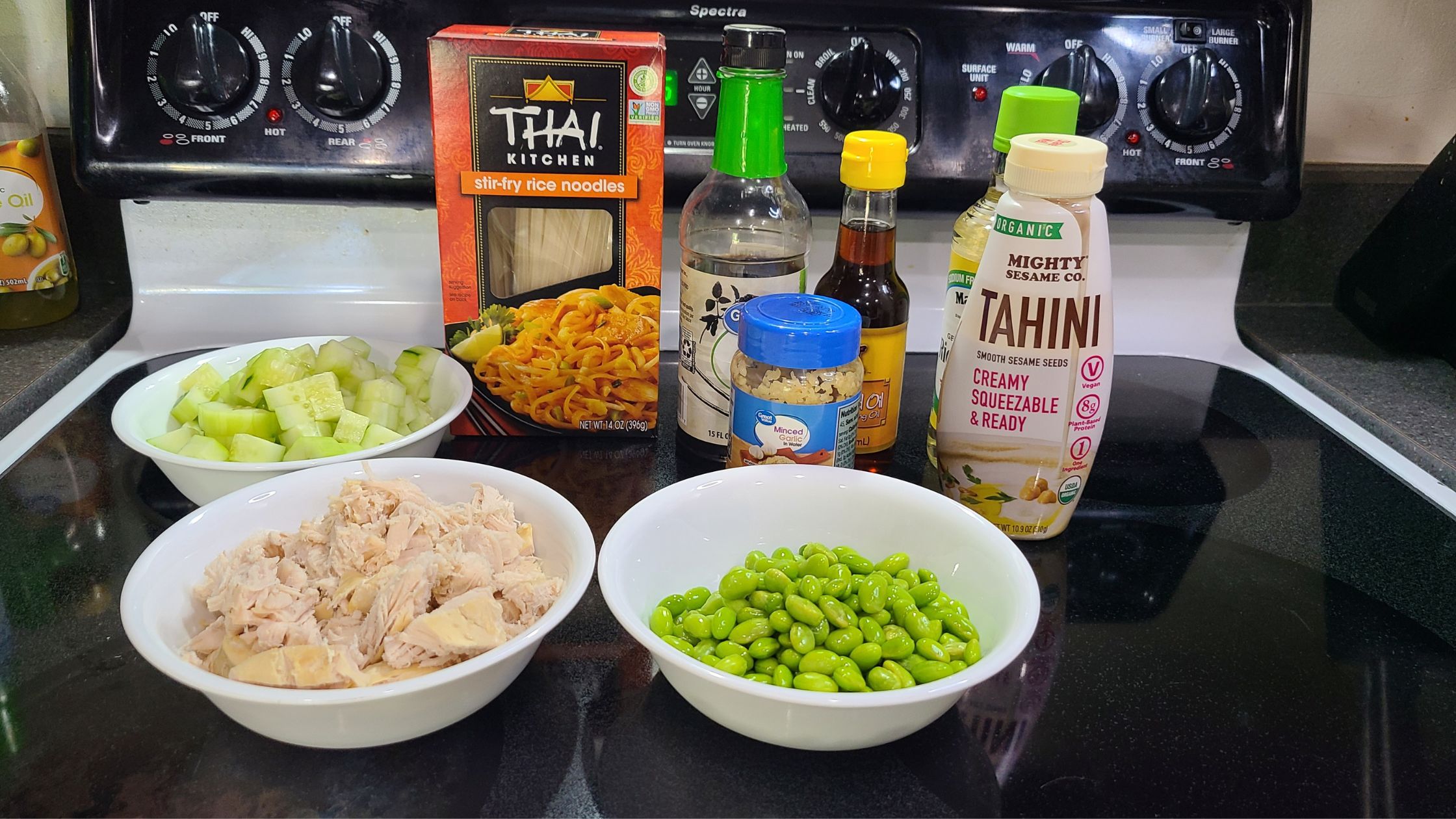 Ingredients for sesame noodle salad, on a stovetop