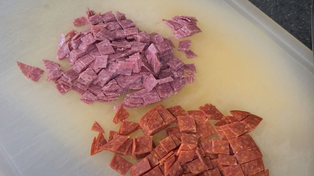 Diced salami and pepperoni on a cutting board