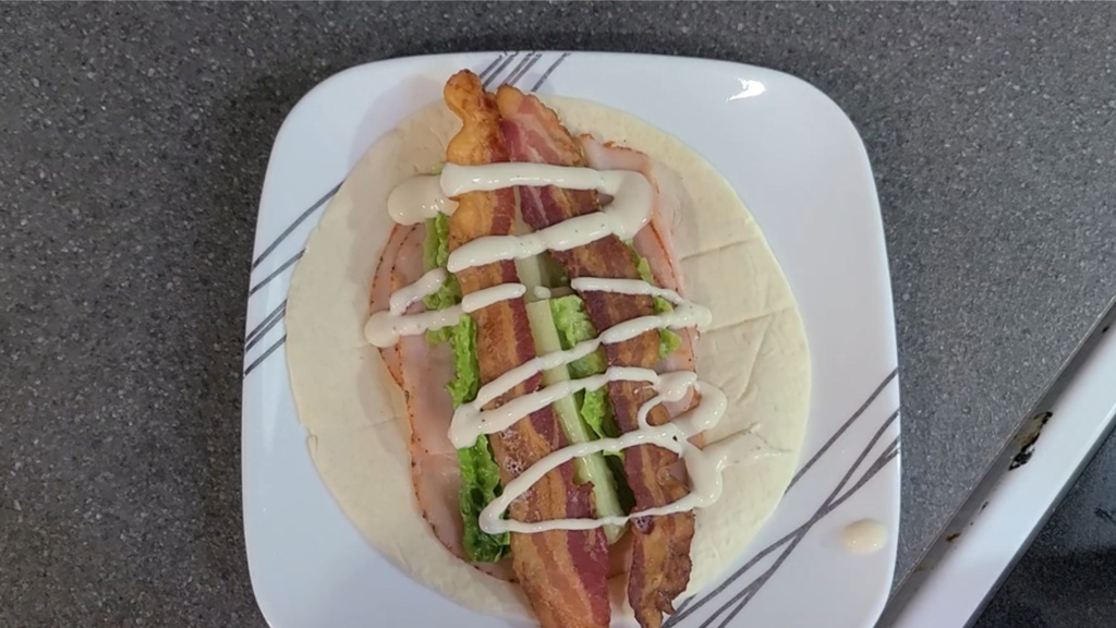A tortilla with all ingredients for Turkey Bacon Ranch Wraps on top